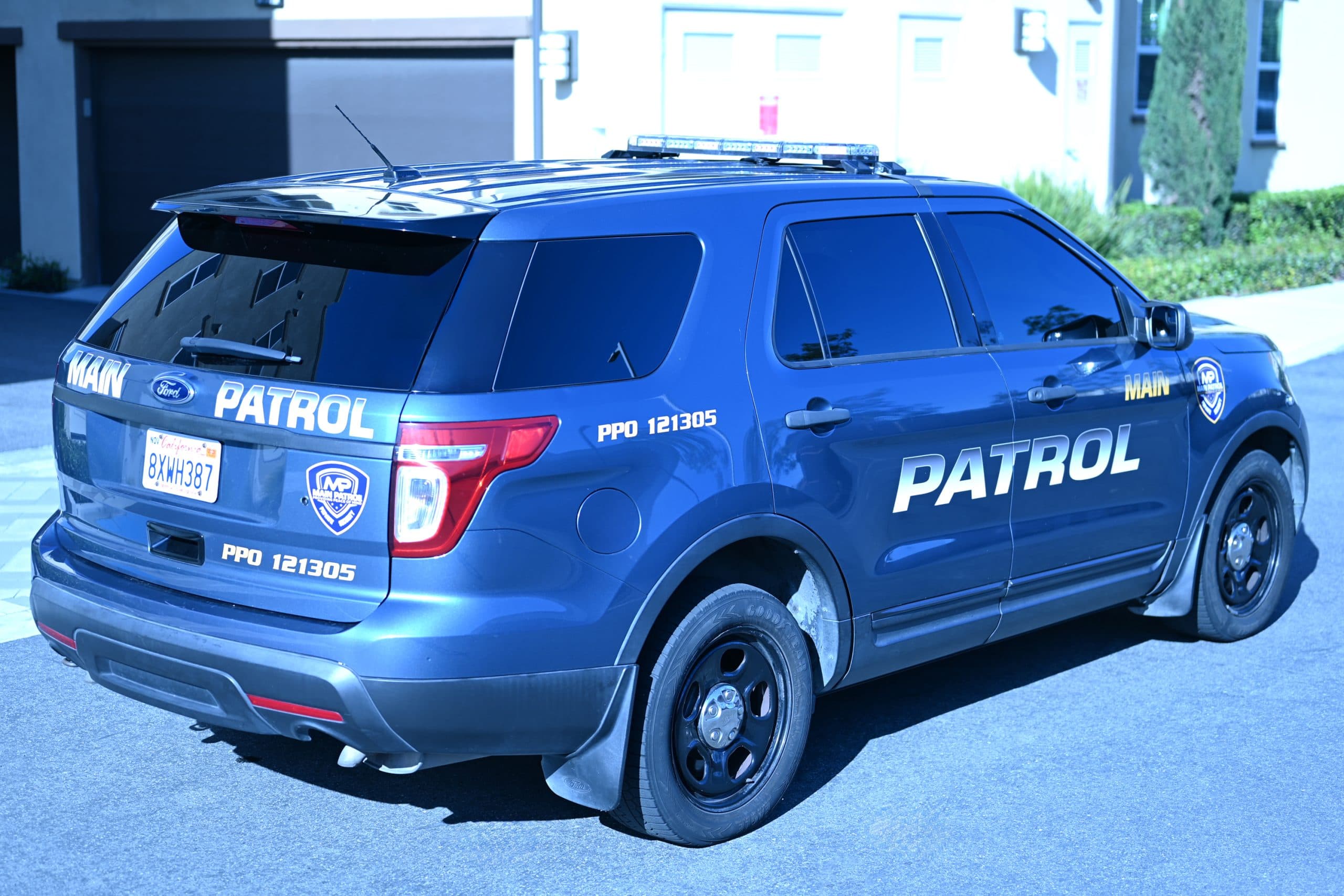 Rear view of a Main Patrol Ford Explorer parked at a property entrance